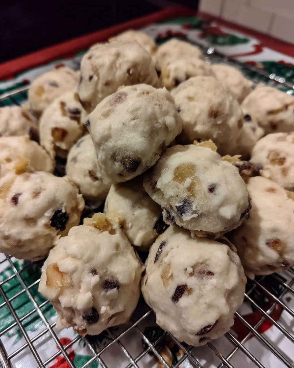 Rolling warm pecan cookies in confectioners sugar