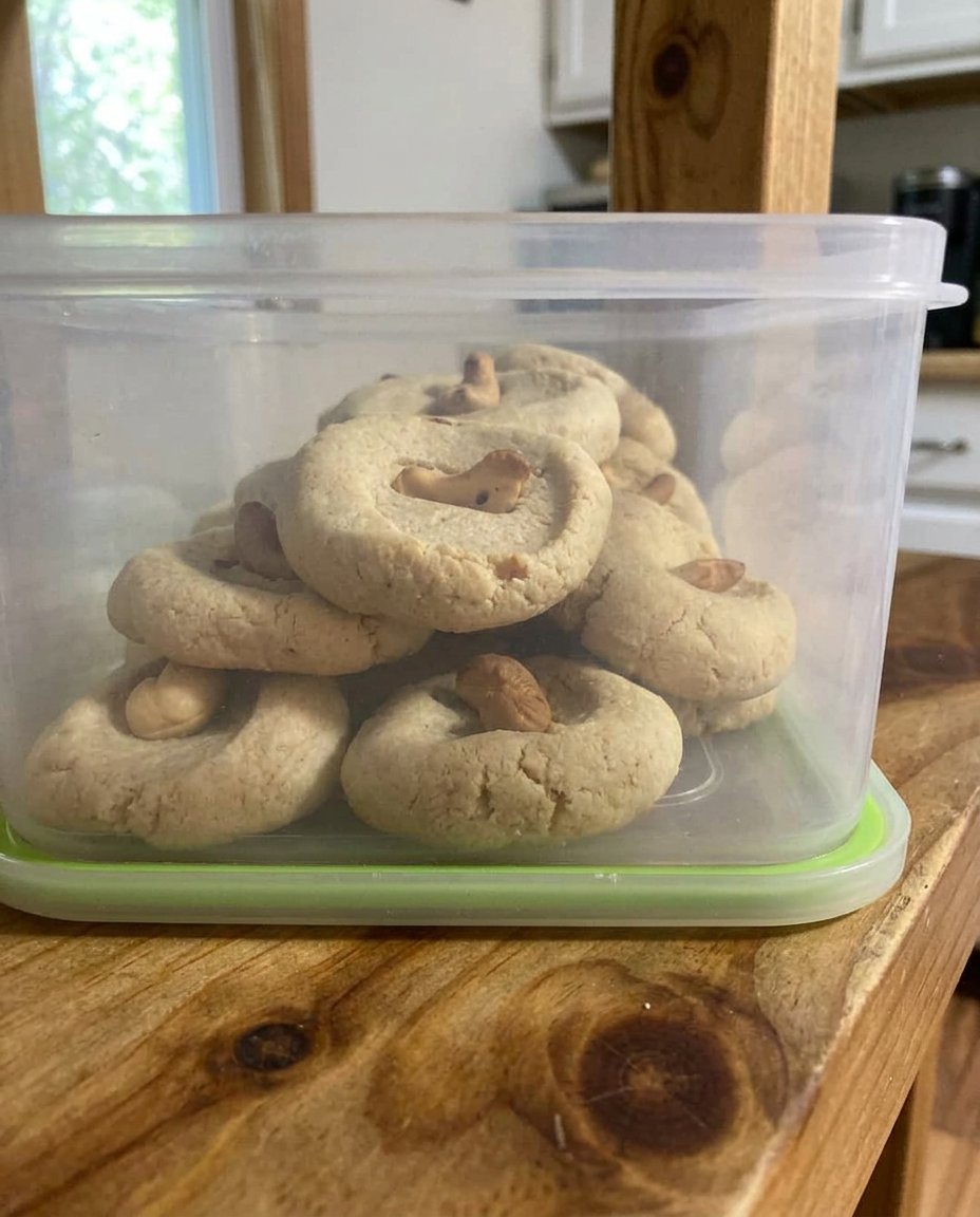 A close up of frosted cashew shortbread cookies on a cooling rack.