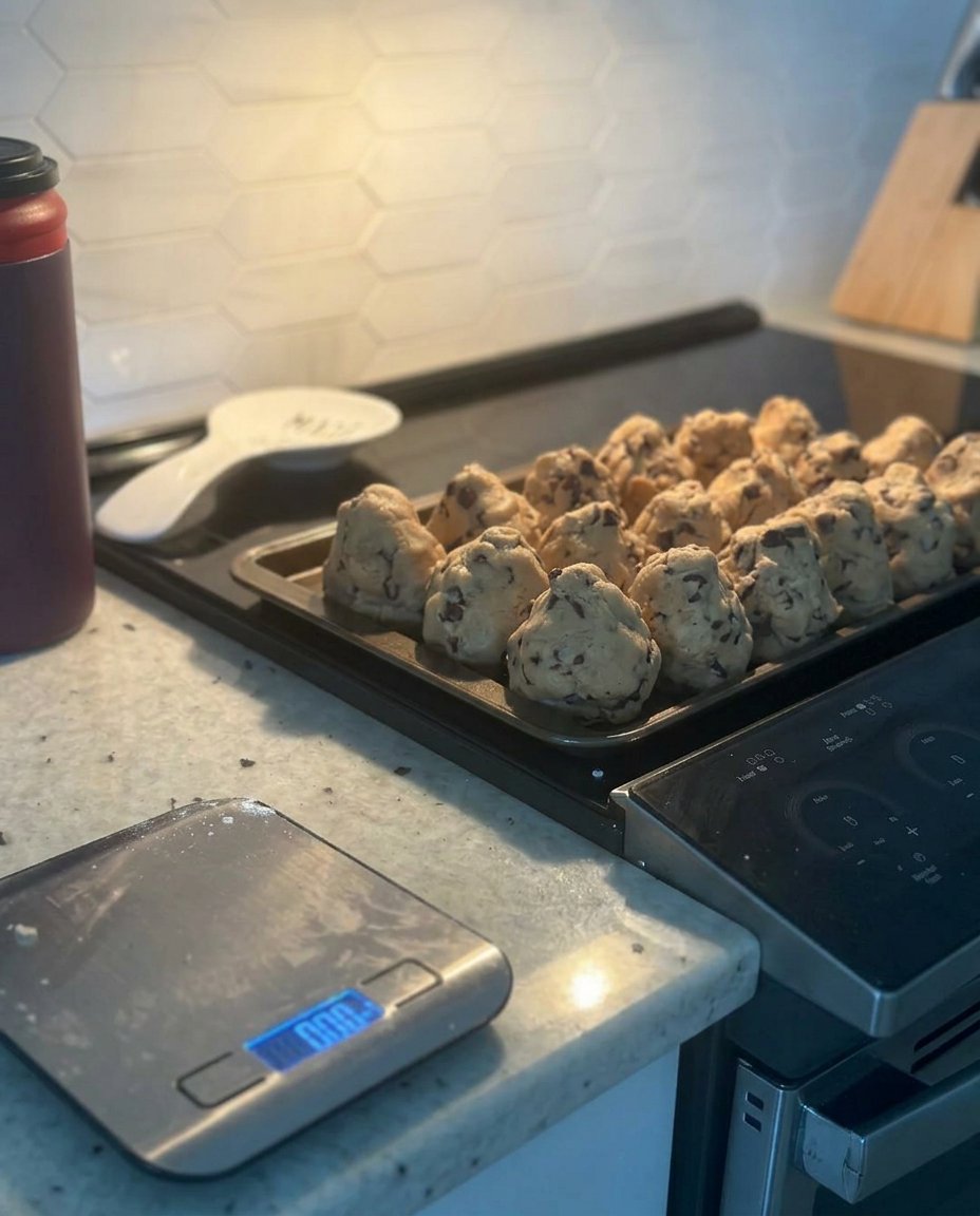 Scooped cookie dough balls resting on a baking sheet.