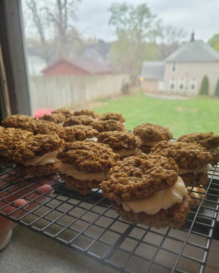 Soft oatmeal cream pies stacked on a cooling rack showing the creamy filling