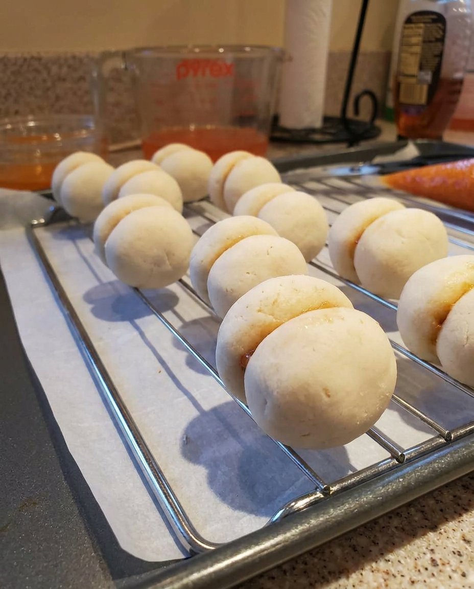 Scooped peach cookie dough balls in a container ready for chilling