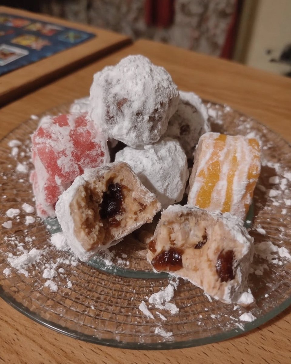 A plate of Amygdalota cookies served with a cup of coffee