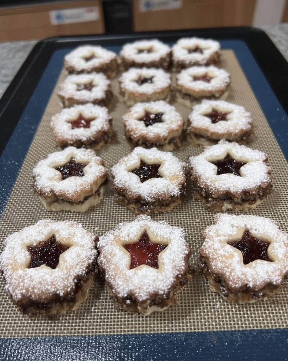 Top down view of raspberry linzer cookies with powdered sugar