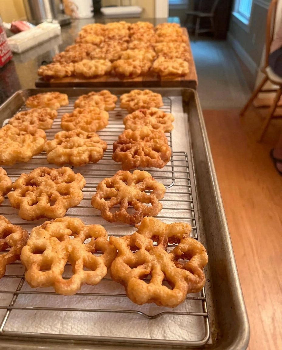 A plate of dusted rosettes next to a steaming cup of dark coffee