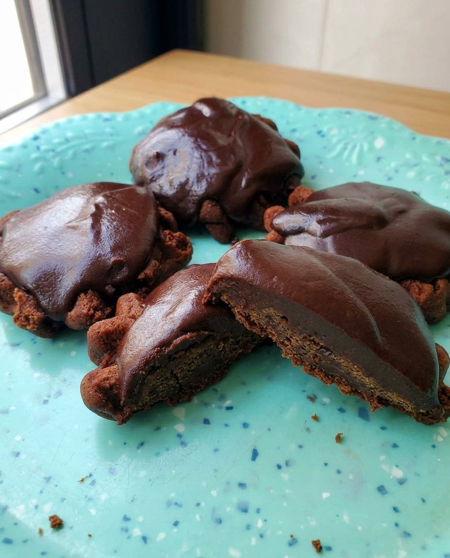 A stack of chocolate caramel turtle cookies served on a white plate.