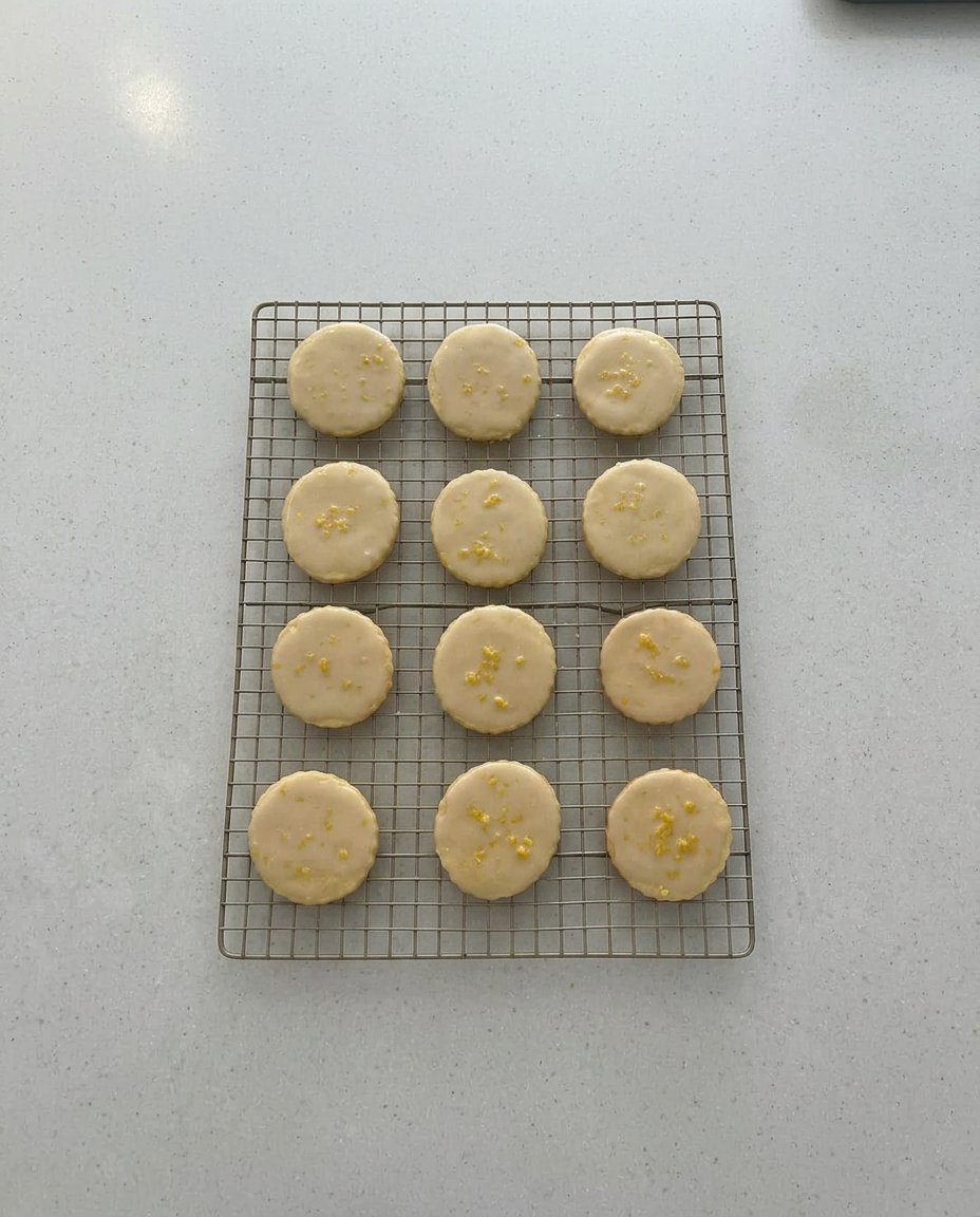 A stack of glazed lemon cookies showcasing a tender crumb and light golden edges.